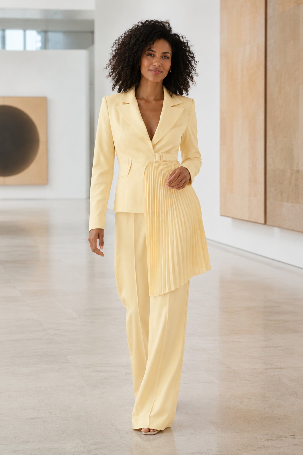 Solevia Pleated Pants Set in pale lemon on a woman walking through a gallery