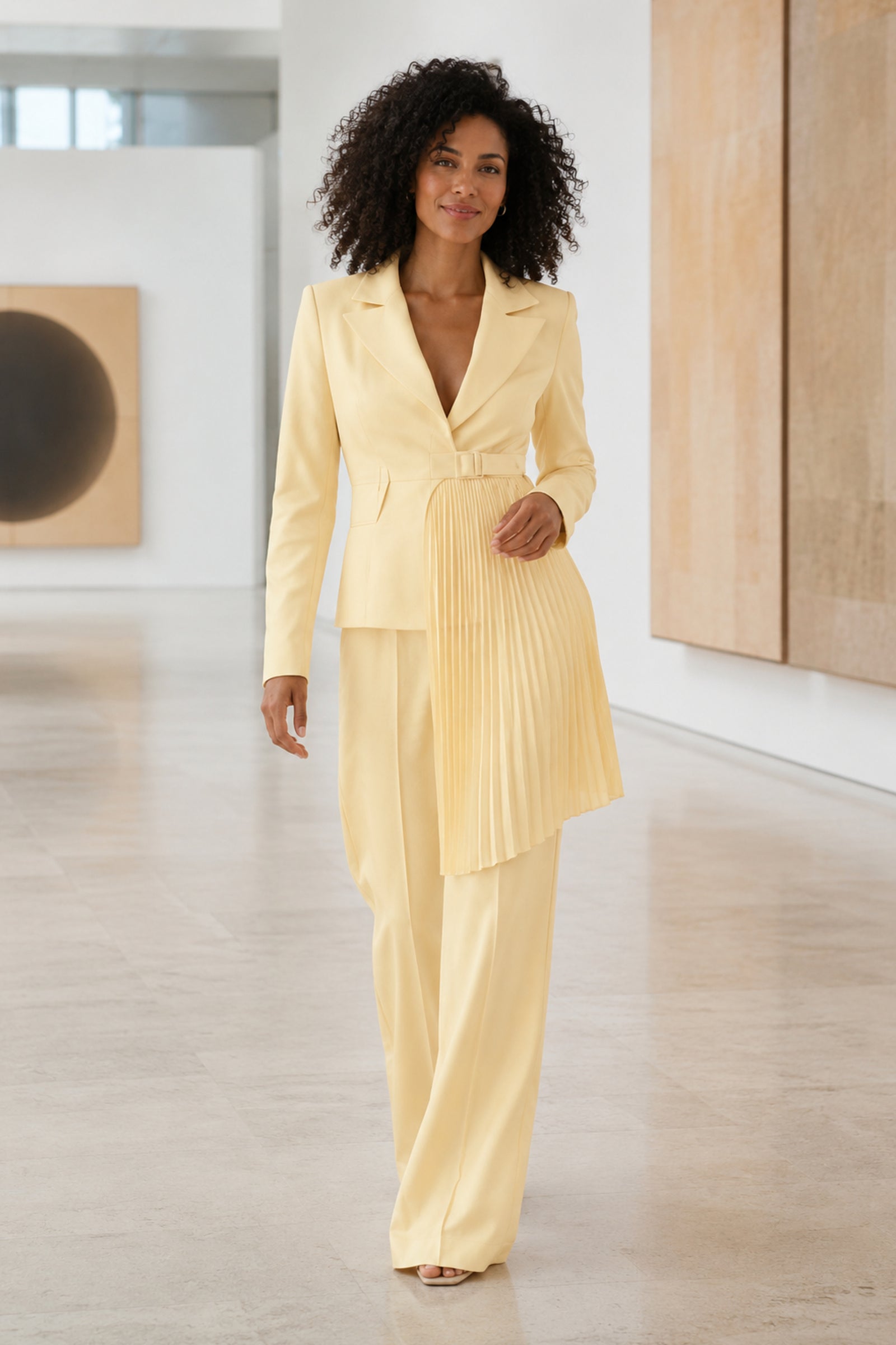 Solevia Pleated Pants Set in pale lemon on a woman walking through a gallery